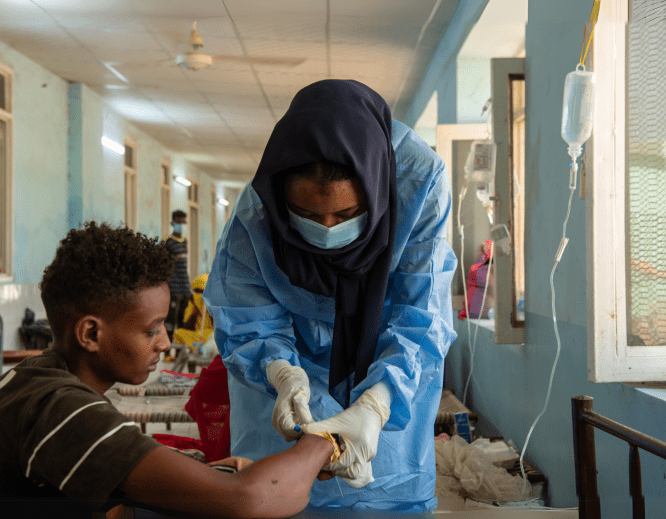 A health worker treats a patient as part of MSF's cholera response in Sudan.