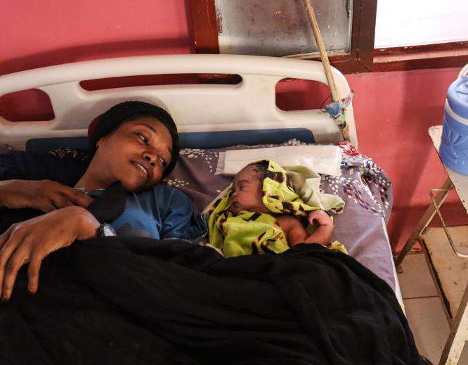 A woman with her baby in a hospital bed in South Darfur, Sudan.