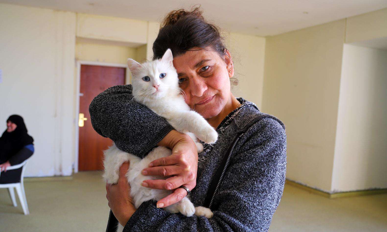 A displaced woman in South Lebanon holding a cat.