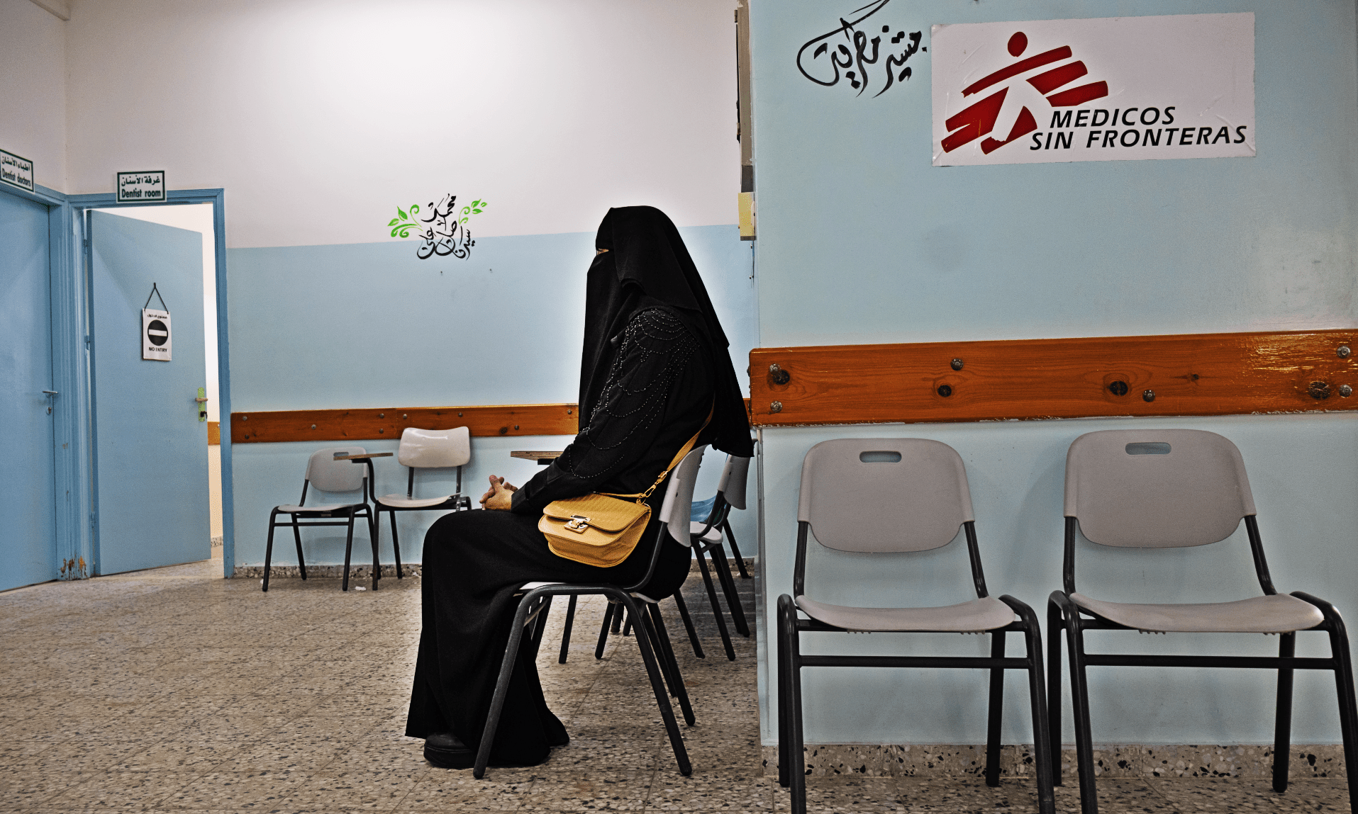 A veiled woman waits in a chair at an MSF facility in Gaza.