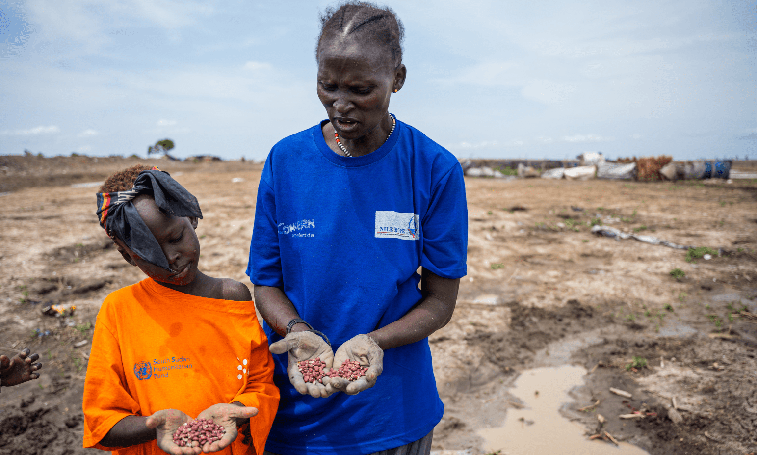 A mother and daughter show in their palms the red bean seeds they are about to plant in the garden plot they are cultivating in Bentiu camp for internally displaced people.