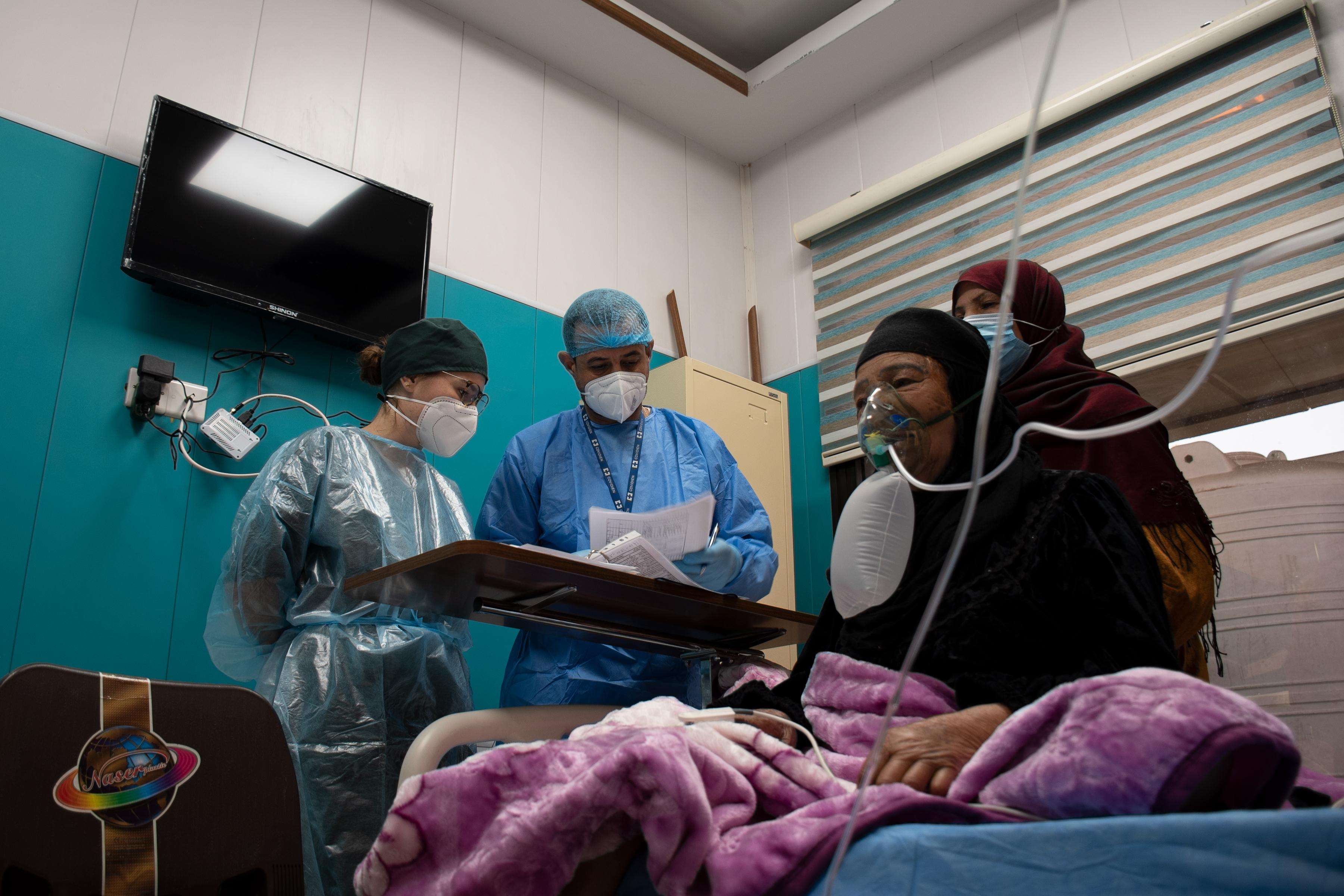 Medics crowded around a patient getting oxygen care