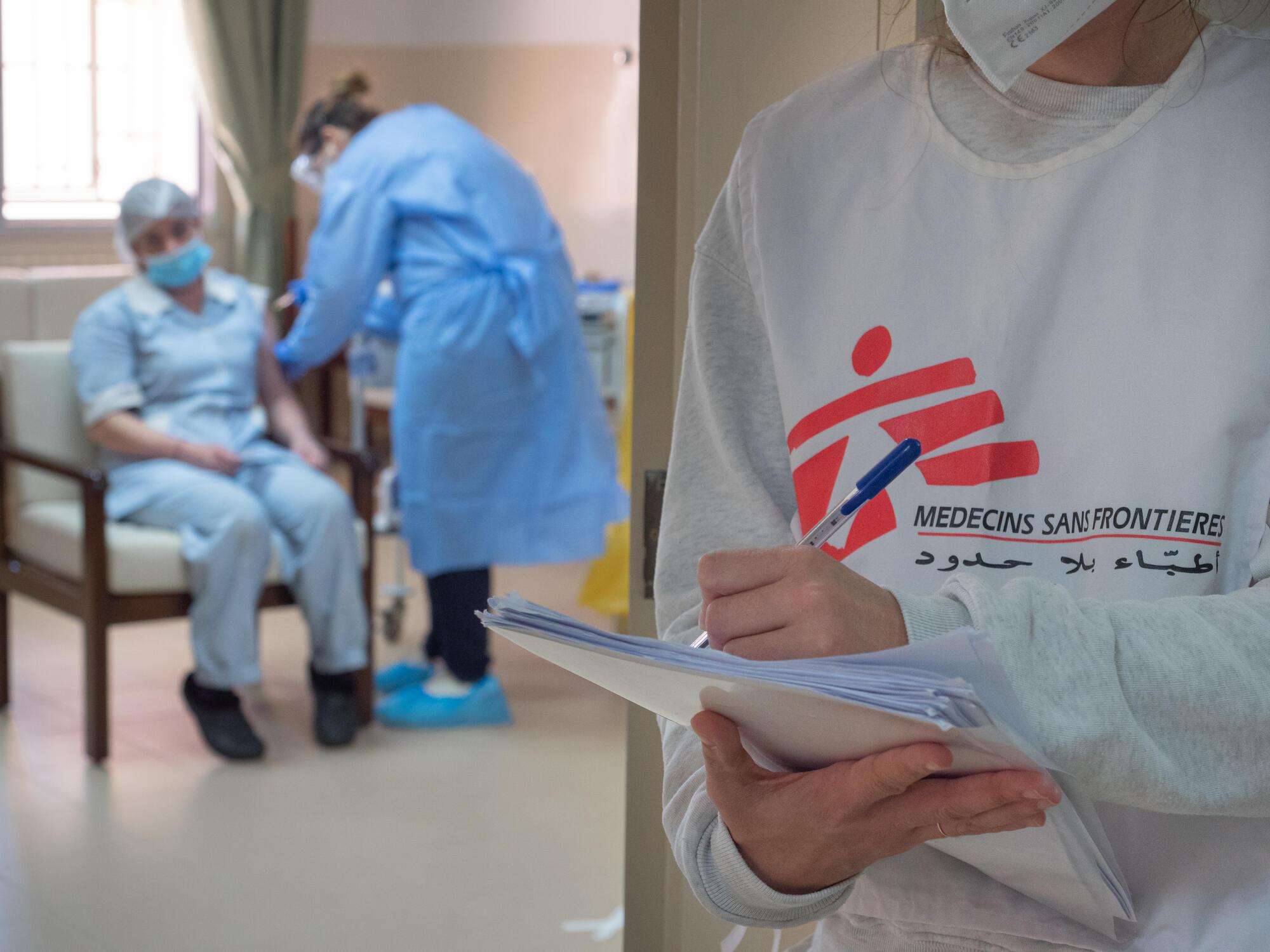 A frontline health worker at a nursing home in Chlifa Baalbak receives her vaccine from an MSF medical staff member.