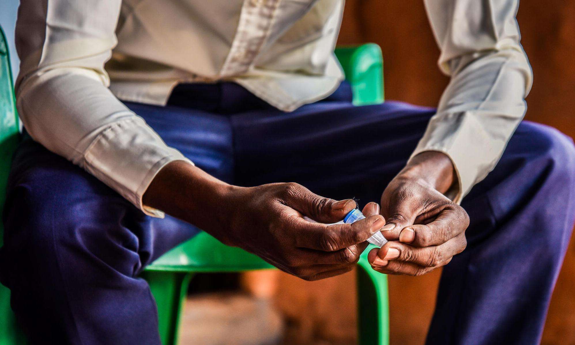 A diabetic refugee from Somalia sits in Dagahaley camp, Kenya, holding his insulin.