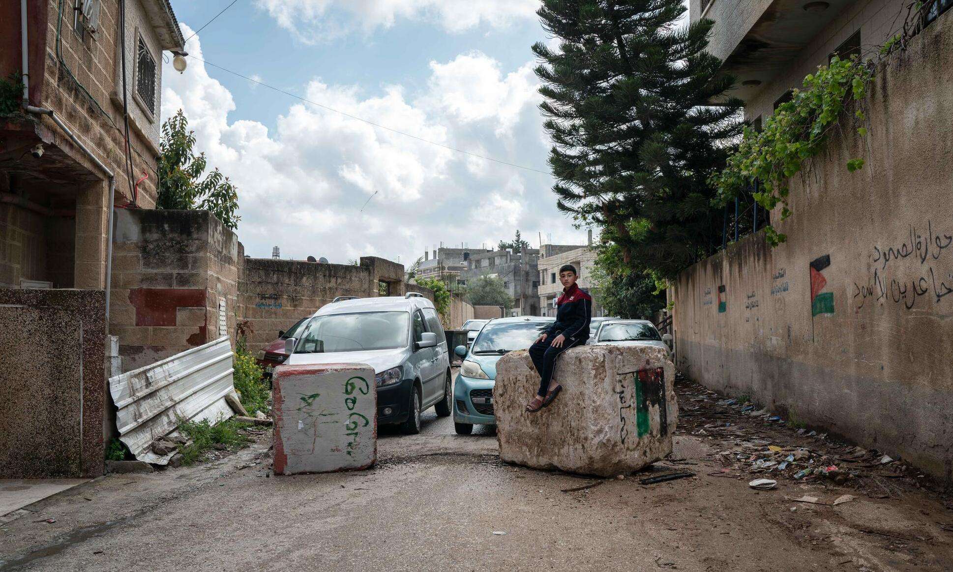 Hussam Odeh, a Palestinian boy, sits on top of the rubble left over after a settler attack on his town, Huwara, West Bank.