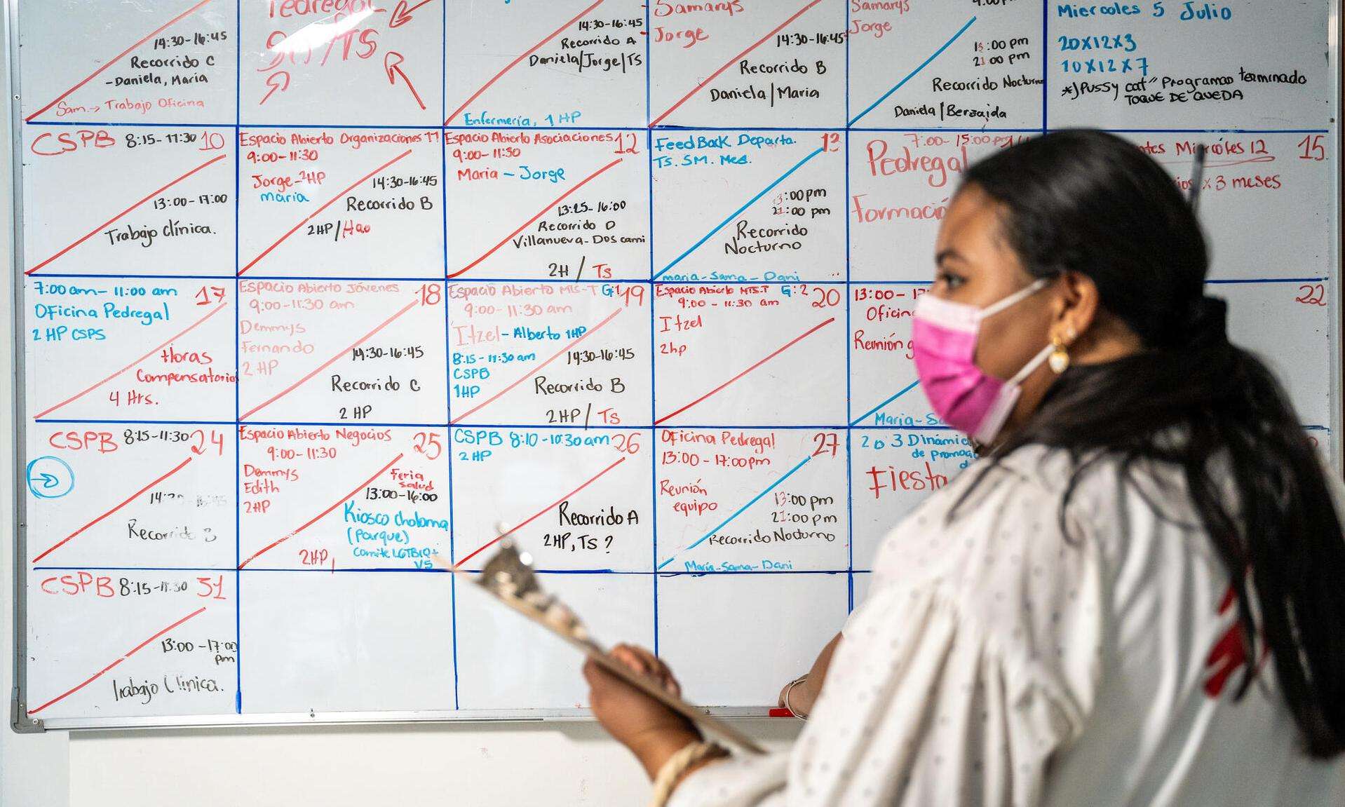 An MSF staff member at the clinic in San Pedro Sula, Honduras, stands before a whiteboard.