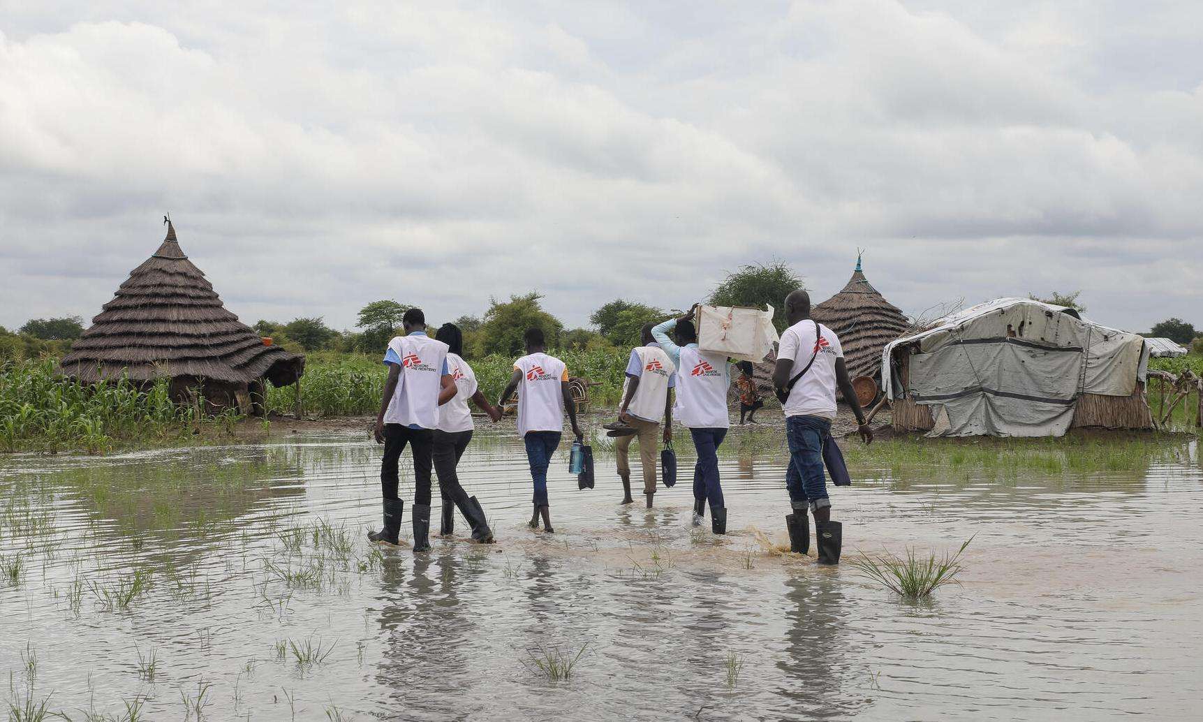 MSF teams in South Sudan wade through a flooded village to deliver medicine. 