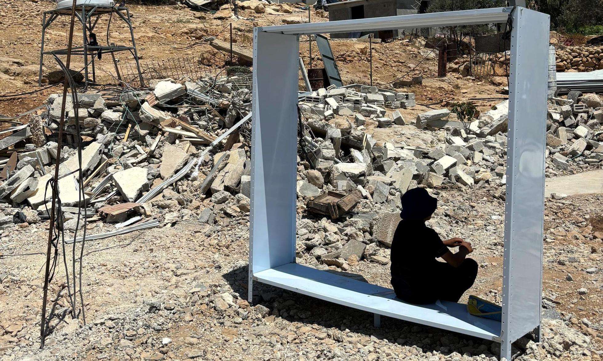 A Palestinian teenager finds shelter from the sun after his home was demolished without warning in Umm al Kheir, Masafer Yatta, West Bank.