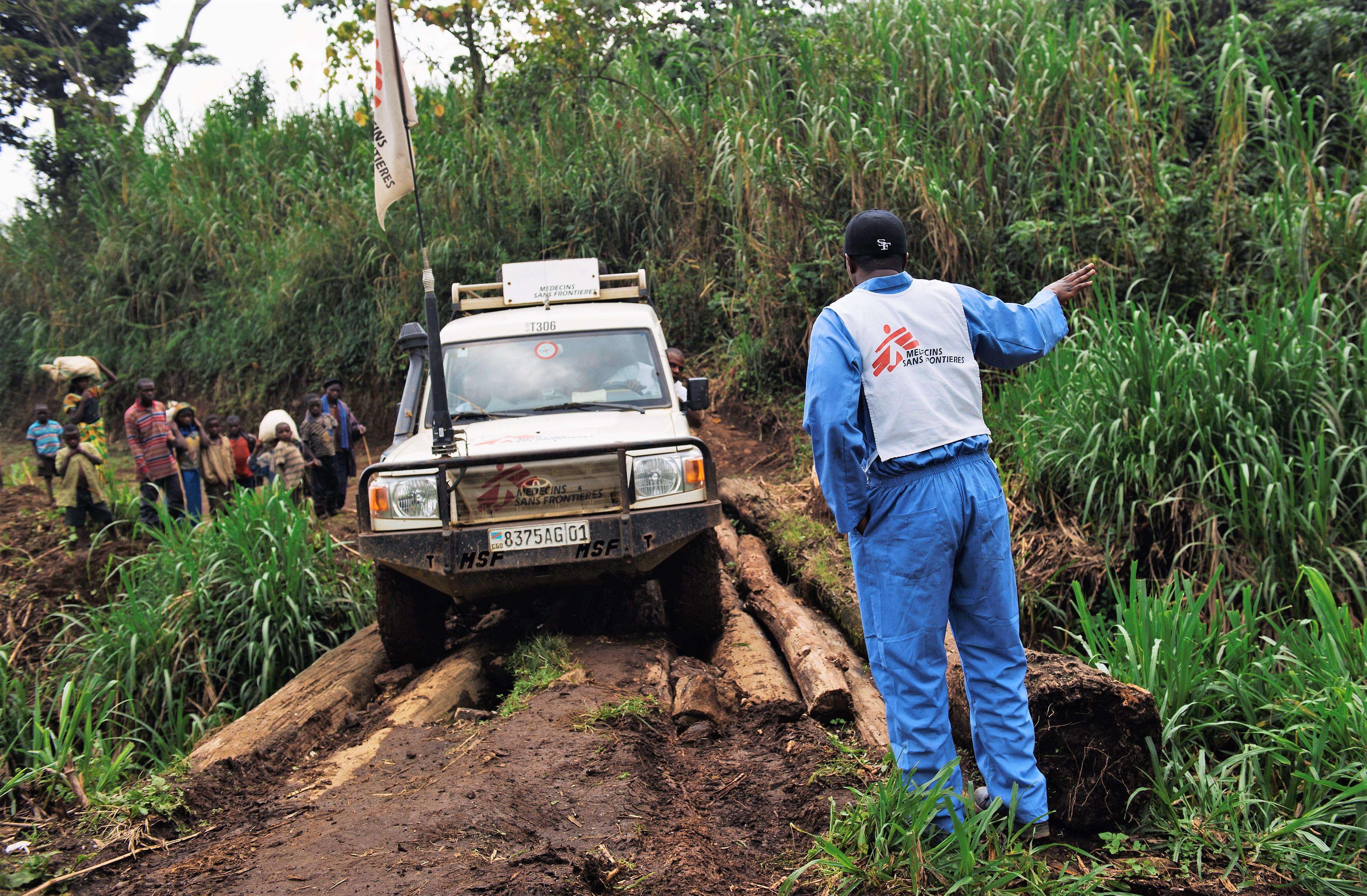 A driver with MSF directs a car over a log-bridge on the road from Nyabiondo towards the village of Kazinga in Masisi territory, in the east of the Democratic Republic of the Congo.