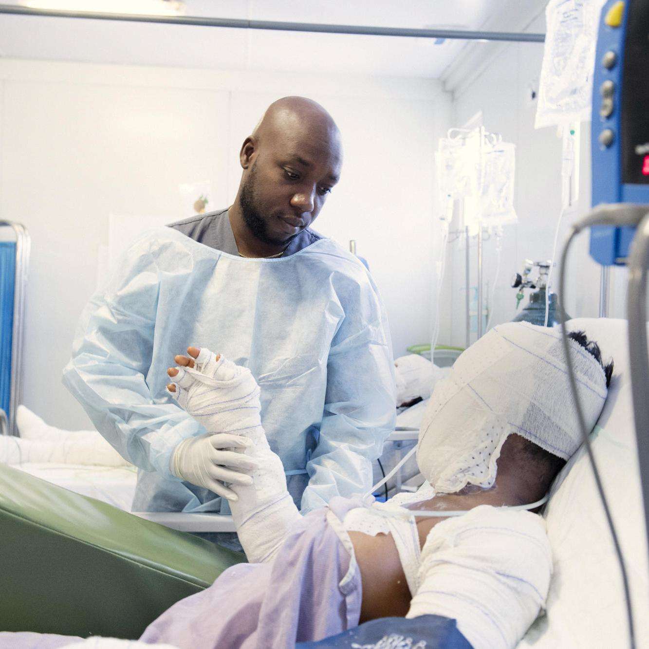 A physiotherapist helps a burn patient in Haiti