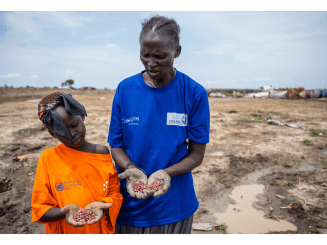 A mother and daughter show in their palms the red bean seeds they are about to plant in the garden plot they are cultivating in Bentiu camp for internally displaced people.