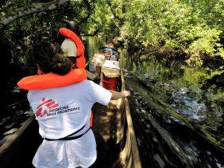 A field worker traveling by pirogue (dugout canoe) to the MSF sleeping sickness mobile team in northern Bandundu Province, DRC. 