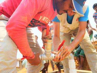 An MSF Water and Sanitation (Watsan) Network Distribution Supervisor and Watsan Manager lead the installation of a submersible pump in a deep well in the Kutupalong-Balukhali Rohingya refugee camp.