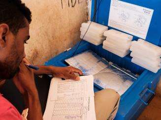 Vaccination Team Supervisor doing a reconciliation of vaccines used on 8 August 2018 after a day's work during a Médecins Sans Frontières (MSF) vaccination campaign in the Mbera refugee camp in southeastern Mauritania.