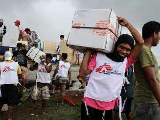 MSF logistician and daily workers unload a truck with humanitarian supplies on the premises of MSF’s tent hospital in Guiuan.