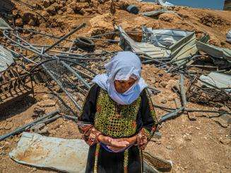 A woman in traditional Palestinian dress in front of the ruins of her home after it was demolished by Israeli forces in Masafer Yatta, West Bank.