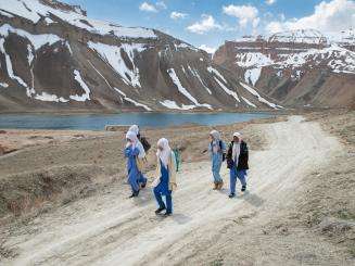 Girls walk to school with mountains of Bamyan province, Afghanistan in the background.