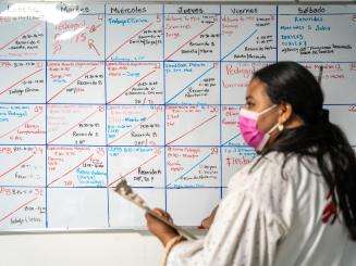 An MSF staff member at the clinic in San Pedro Sula, Honduras, stands before a whiteboard.