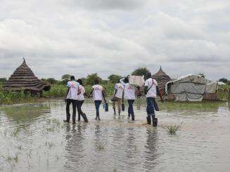 MSF teams in South Sudan wade through a flooded village to deliver medicine. 