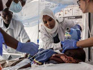 Dr. Faiza Hamed Hangata (center), who is from El Geneina in West Darfur, Sudan, tries to resuscitate a child with tracheal bronchitis and septic shock.