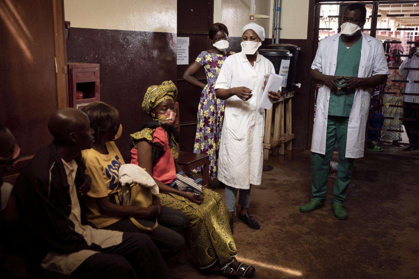 A group of medics speaks to a group of patience in a room.