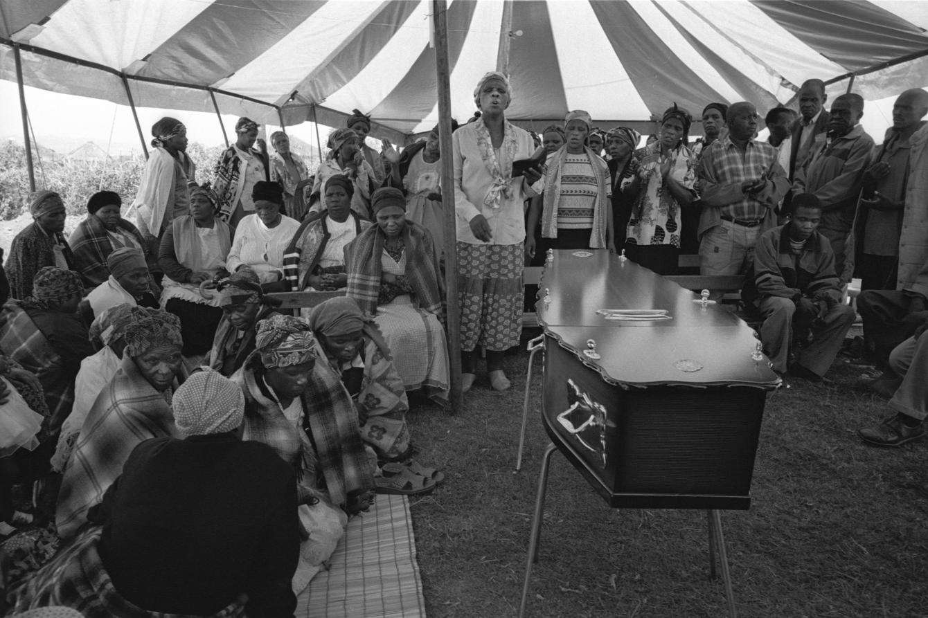 A black and white photograph of a funeral scene.