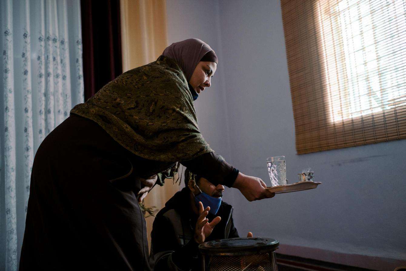 Woman hands her husband a plate with a glass of water