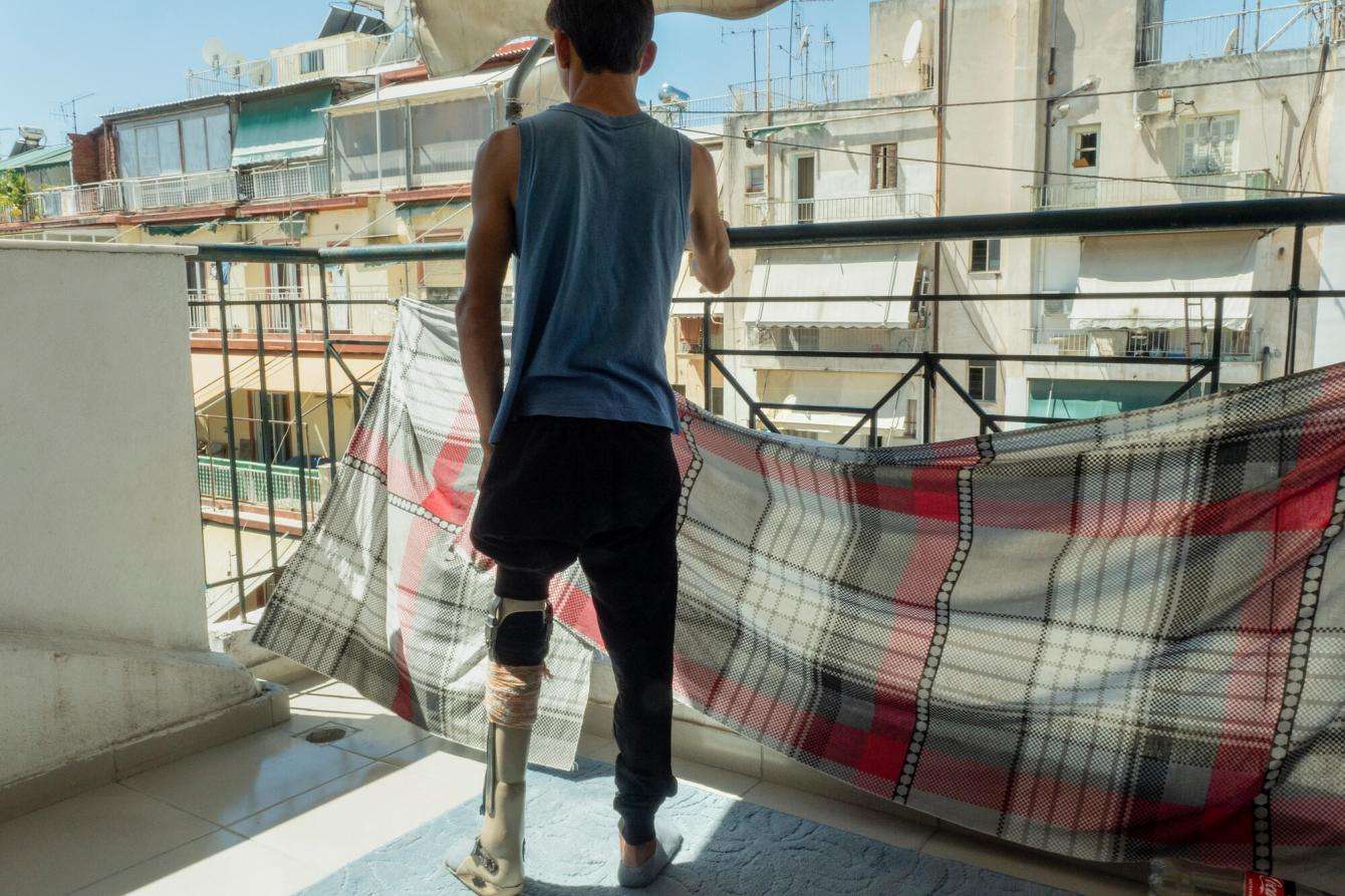 Man stands on the patio of his apartment