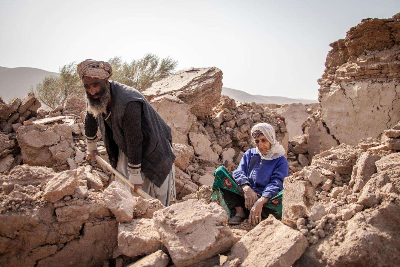 An Afghan man digs through the remains of his house beside his mother after the earthquake in Herat, Afghanistan. 