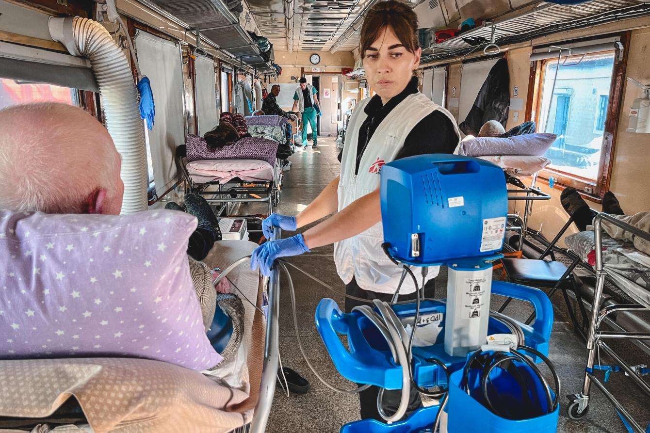 An MSF team member checks the blood pressure of a patient on the MSF medical evacuation train in Ukraine