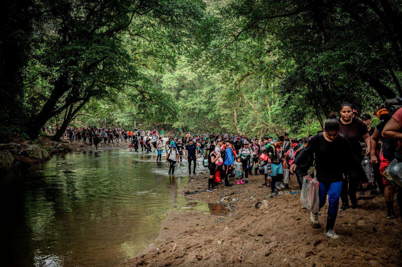 Migrants cross the Acandí and Tuquesa rivers on their way through the jungle of the Darién Gap.