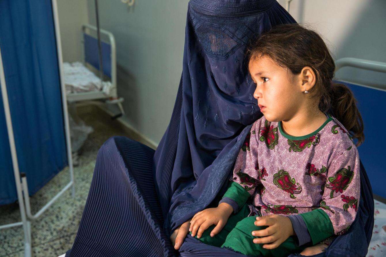 An Afghan mother in a burqa holding her child at Mazar-i-Sharif Regional Hospital in Afghanistan.