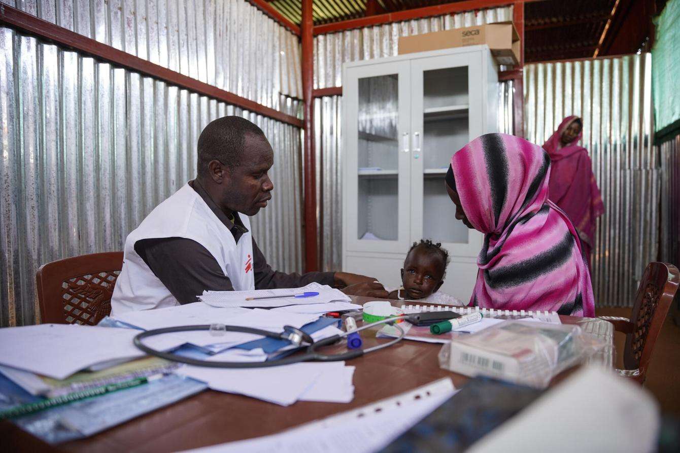 An MSF staff member attends to a mother and child patient at the clinic in Zamzam camp in Sudan.