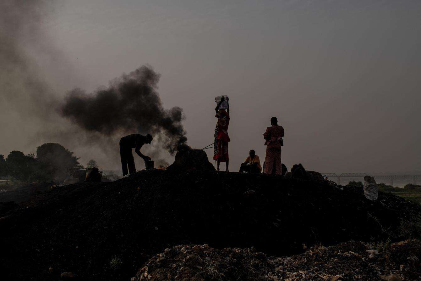 People roast cow skin on a hill by the Benue River in Nigeria.