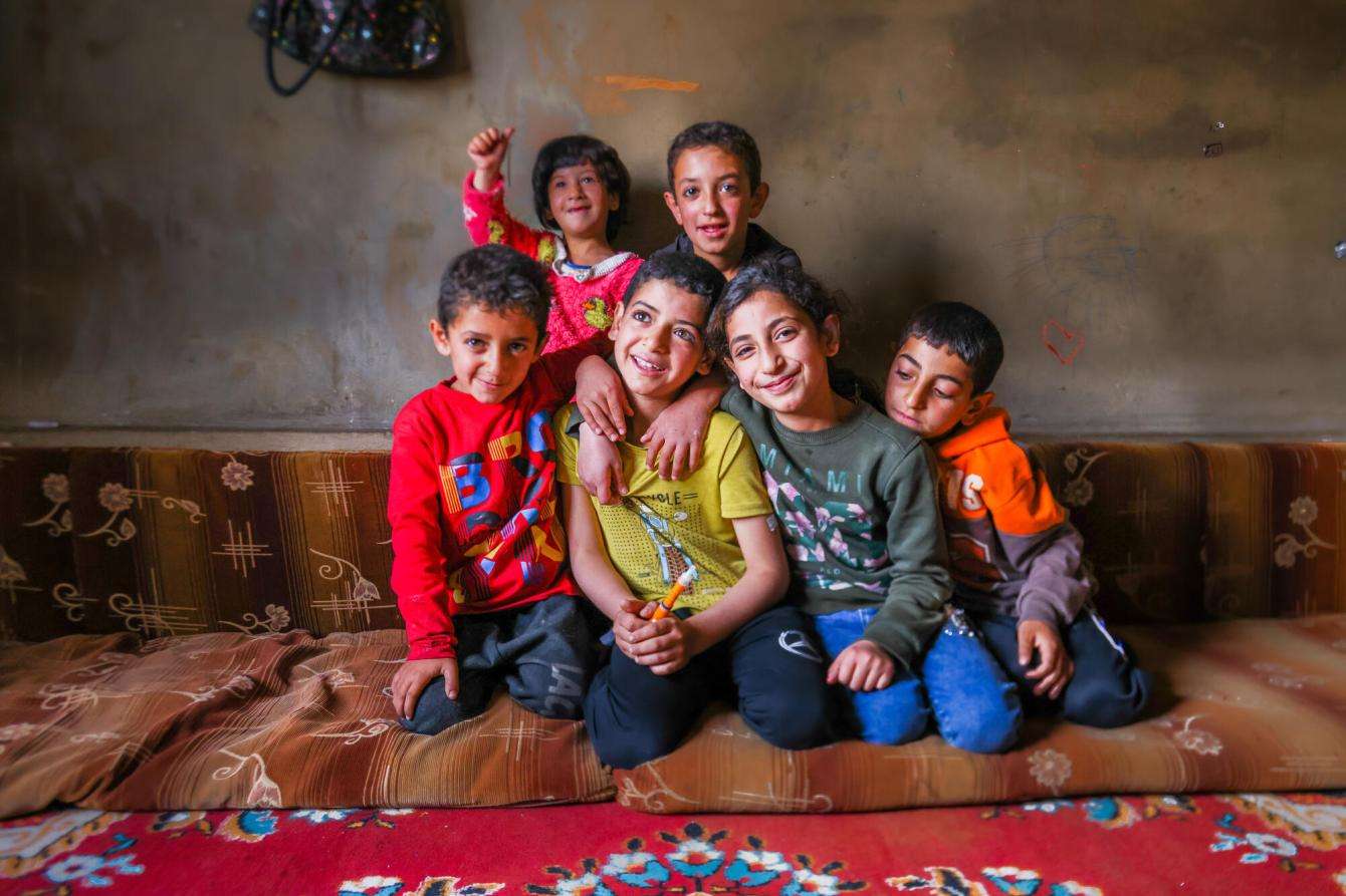 A young boy with diabetes holds his insulin pen surrounded by other Syrian refugee children in Lebanon.