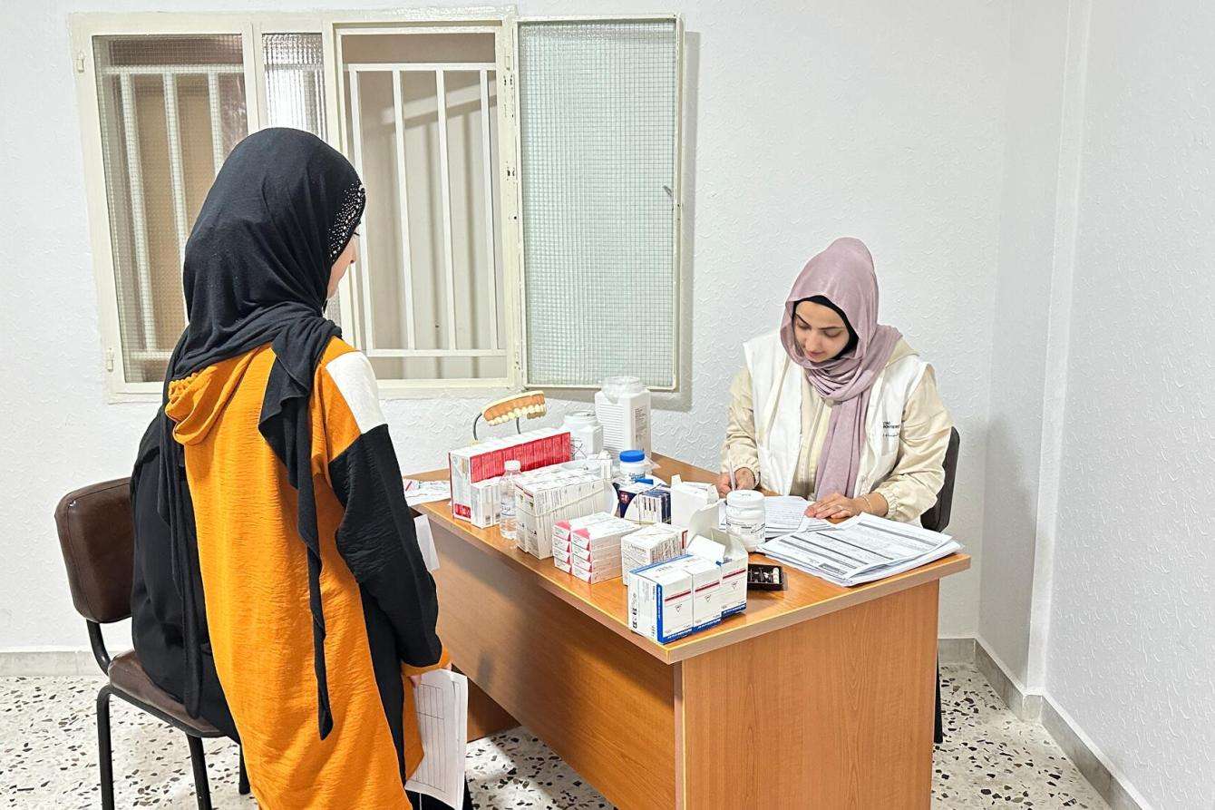 A young girl talks to an MSF staff member at a clinic in Lebanon.