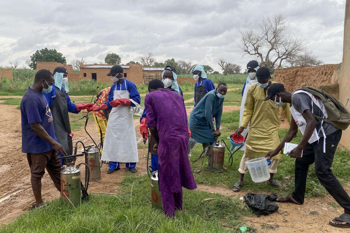 Magaria residents prepare pesticide to treat houses in Niger.