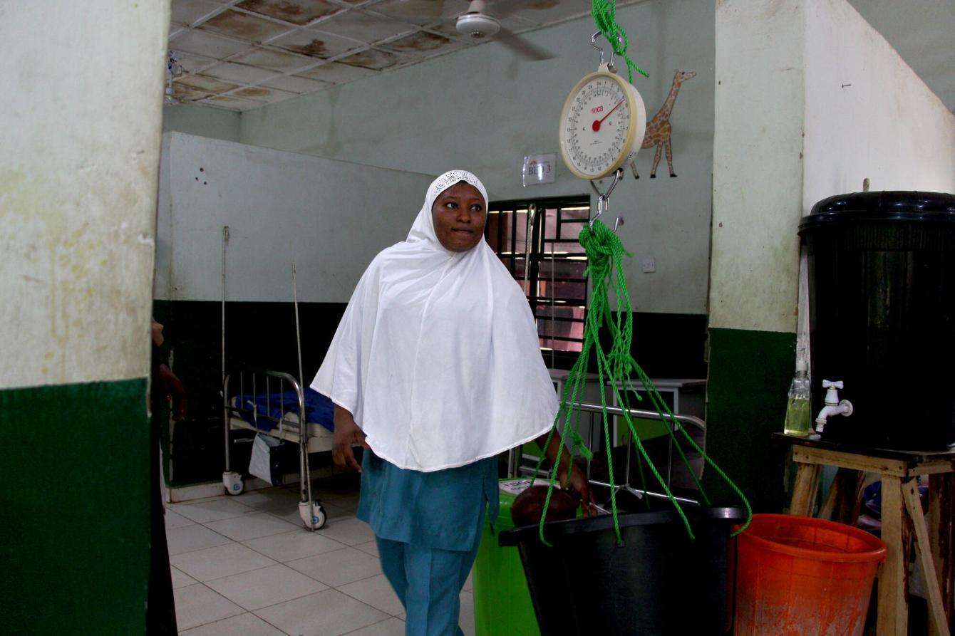 An MSF nurse weighs a child as part of a malnutrition screening in Nigeria. 