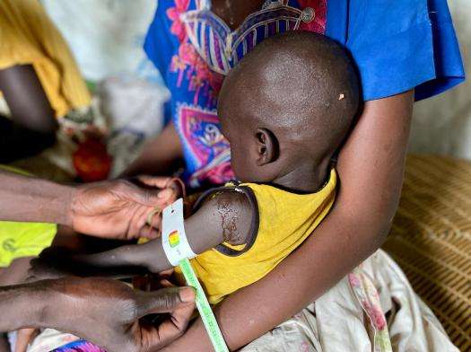 A nurse measures a child's upper arm circumference in South Sudan.  