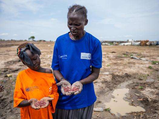 A mother and daughter show in their palms the red bean seeds they are about to plant in the garden plot they are cultivating in Bentiu camp for internally displaced people.