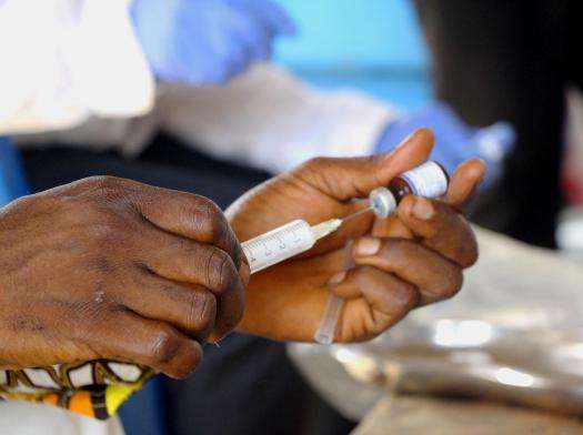 An MSF fills a syringe with a dose of measles vaccine in DRC. 