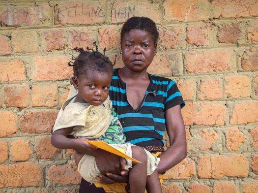 A mother holds her child at a vaccine clinic in DRC. 