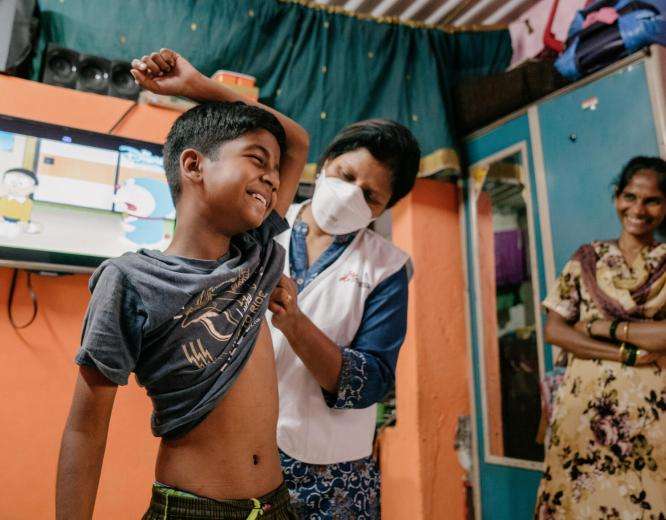 Prachi, MSF nurse examines a young boy for tuberculosis in India.