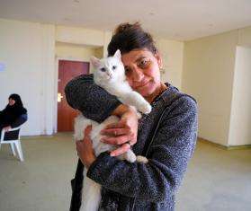 A displaced woman in South Lebanon holding a cat.