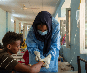 A health worker treats a patient as part of MSF's cholera response in Sudan.