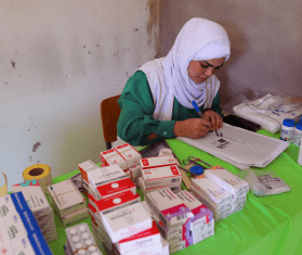 Hala Hussein, MSF dispenser, receives patients after their consultations to give them their prescribed medications.