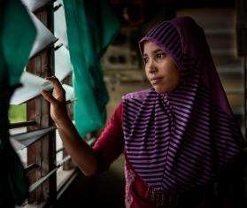 A Rohingya refugee looks out of her window in Malaysia