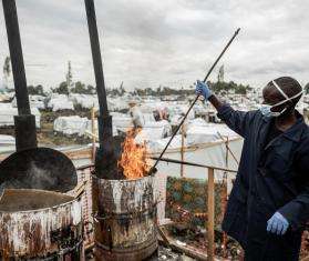 An internally displaced person burns items infected by cholera in a camp in Democratic Republic of Congo.