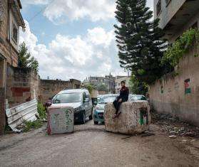 Hussam Odeh, a Palestinian boy, sits on top of the rubble left over after a settler attack on his town, Huwara, West Bank.