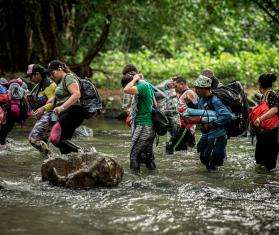 Migrants cross a river in the Darien Gap 